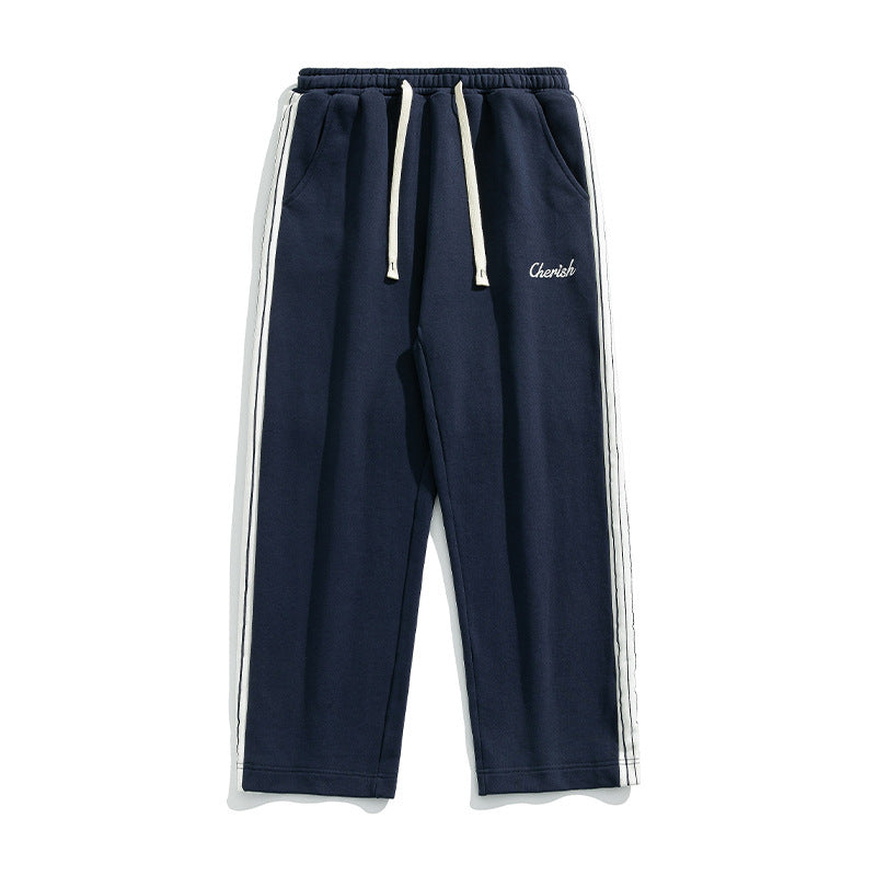 Loose athleisure pants men in navy blue with white side stripes and drawstring waistband