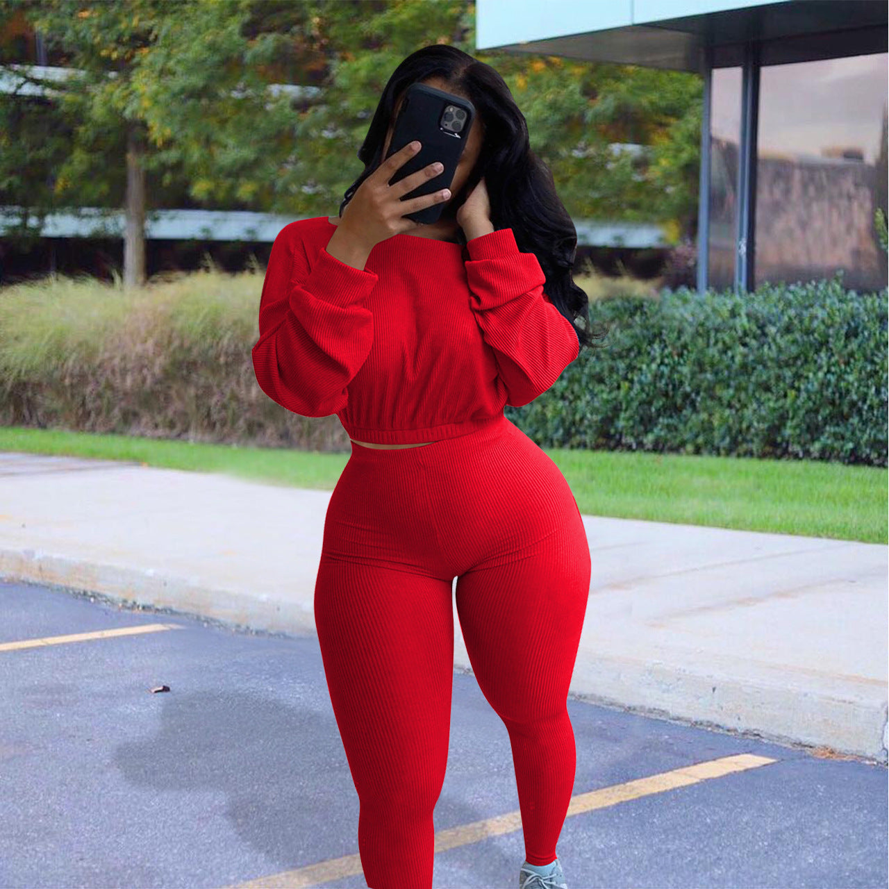 Model wearing a red autumn ribbed athleisure suit, featuring a cropped top and fitted leggings