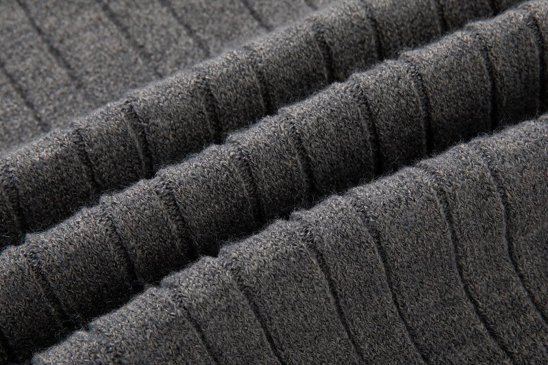 Close-up of a dark gray long sleeve cable knit pullover with textured ribbed pattern