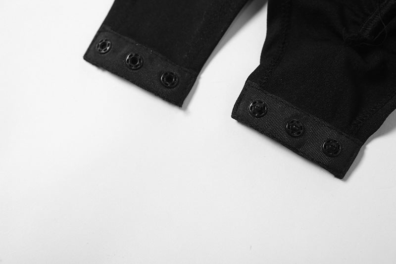 Close-up of the black mesh contrast bodysuit showcasing button details on the sleeves