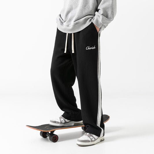 Stylish black loose athleisure pants men with side stripes, perfect for casual wear and skateboarding