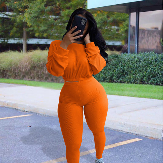 Model wearing an autumn ribbed athleisure suit in orange, perfect for stylish fall outings