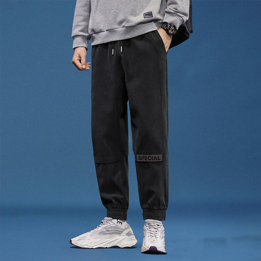 Men's reflective athleisure pants in black with elastic waist and tapered fit for comfortable wear